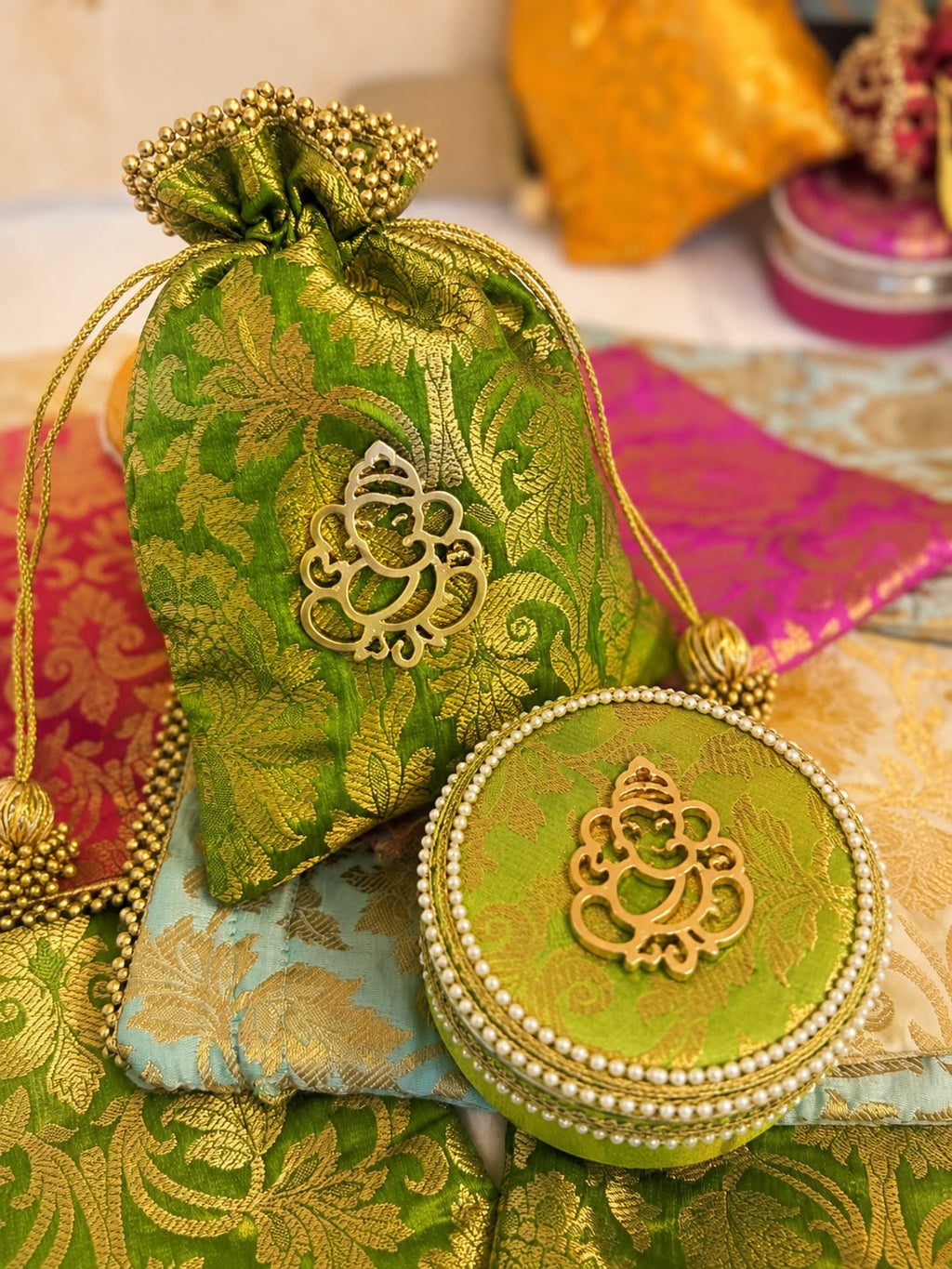 Green Banarasi brocade potli and pearl-edged box combo with gold Ganesha motif by Sache