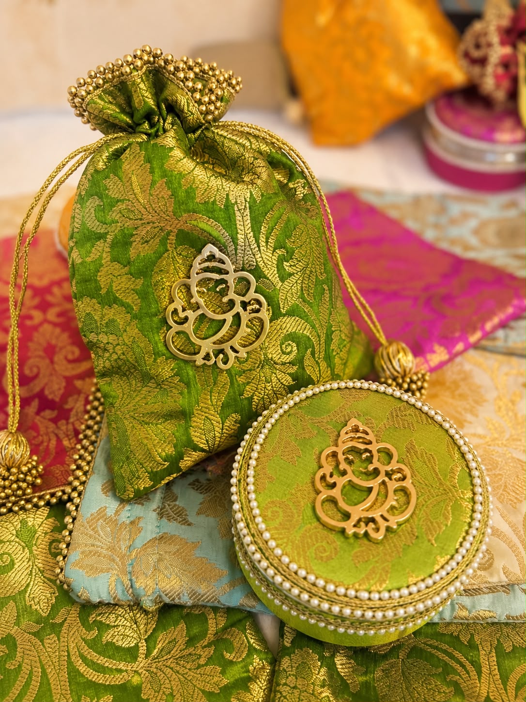 Green Banarasi brocade potli and pearl-edged box combo with gold Ganesha motif by Sache