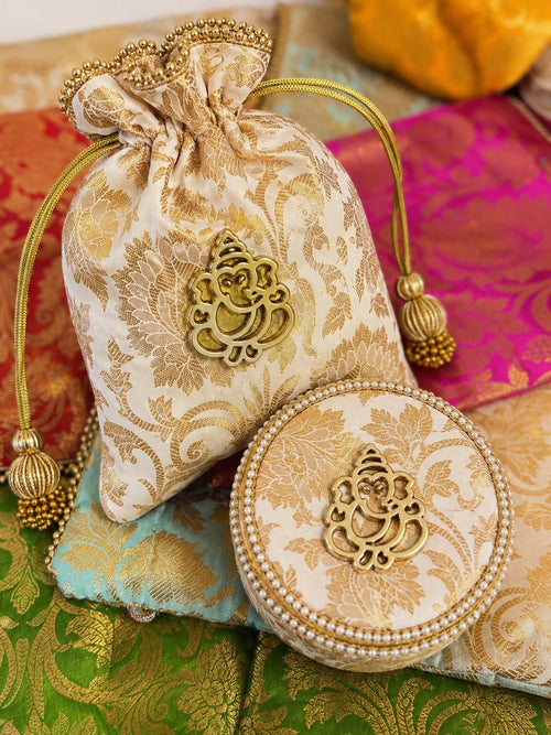 Ivory Banarasi brocade potli and matching pearl-trimmed round box with gold Ganesha motif, a Sache Navratri return gift set