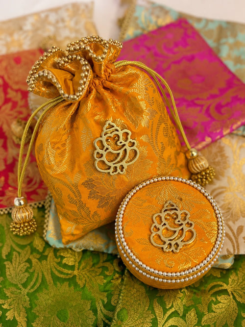 Mustard gold Banarasi brocade potli and box combo with gold Ganesha motif and tassels by Sache