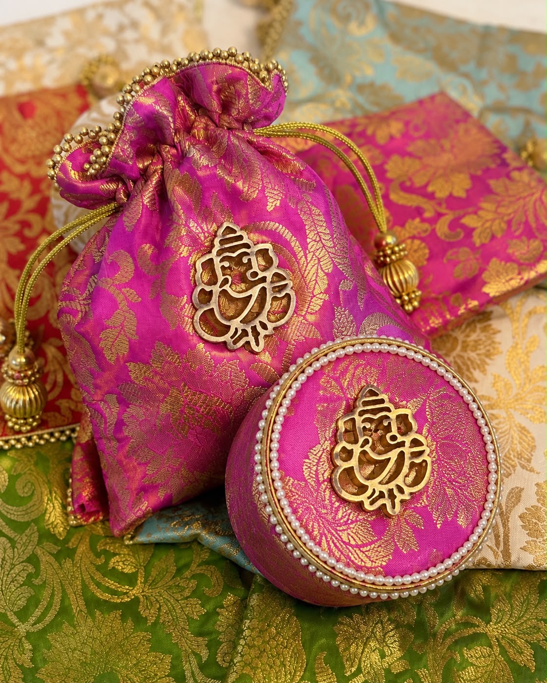 Rani pink Banarasi brocade potli and matching round gift box with gold Ganesha motif, Sache Golu return gift