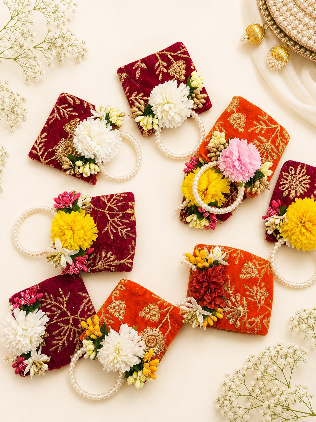 Assorted maroon and orange velvet zari coin potlis with white, yellow and red flowers, Sache Navratri return gifts in bulk