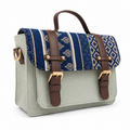 Sage green mini satchel with a handwoven indigo ikat flap, gold buckles and top handle, on a white background