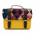 Mustard yellow mini satchel with a multicolour handwoven kilim flap, gold buckles and top handle, on a white background