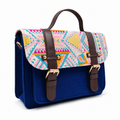 Cobalt blue mini satchel with a pastel handwoven aztec flap, gold buckles and top handle, on a white background