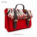 Red mini satchel with a multicolour handwoven ikat zigzag flap, gold buckles and top handle, on a white background